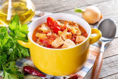 Paprikalı tavuk güveci, ahşap zemin üzerinde soğan ve ekşi krema. Geleneksel Macar yemeği Paprikash. Seçici odak.