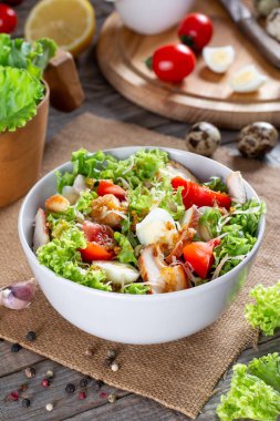 Sezar salatası füme tavuk ve ahşap bir masada parmesan.