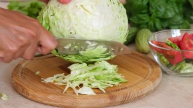 Woman hands cut fresh cabbage to make salad, homemade food. Tasty organic food ingredients. Healthy diet nutrition