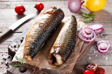 İştah açıcı füme balık uskumrusu, eski ahşap masa arkasında.