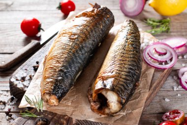 Sarımsak, biberiye ve baharat ile bir doğrama Tahtası üzerinde füme uskumru. Koyu rustik arka plan üzerinde