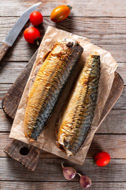 İştah açıcı füme balık uskumrusu, eski ahşap masa arkasında. Üst görünüm.