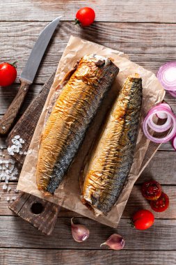 Sarımsak, biberiye ve baharat ile bir doğrama Tahtası üzerinde füme uskumru. Koyu rustik arka plan üzerinde