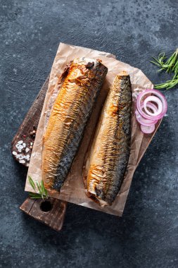 Köy arka planında ahşap bir tahtanın üzerinde nefis tütsülenmiş uskumru. Üst görünüm.