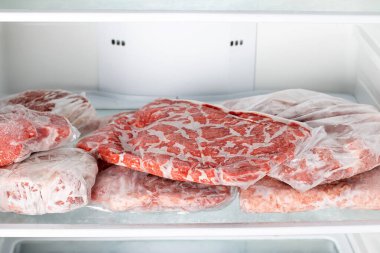 Chicken beef and pork Packed in plastic bags in the white freezer. Frozen raw meat. Frozen food clipart