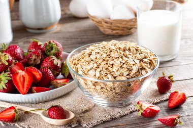 Diyet kahvaltısı - bir kase yulaf lapası, böğürtlen ve taze süt ahşap masa üzerinde - sağlık ve diyet konsepti