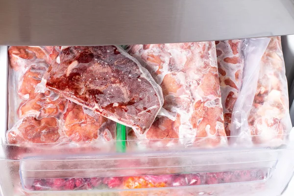 Freezer Filled with Meat and meat frozen products. Meat Frozen in Plastic Bags Food Reserve Stored for Food Preparation. Frozen food