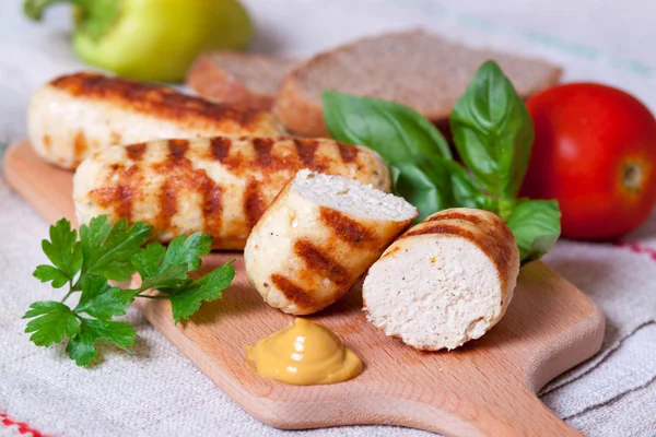 Saucisses de poulet maison grillées sur un fond en bois — Photo