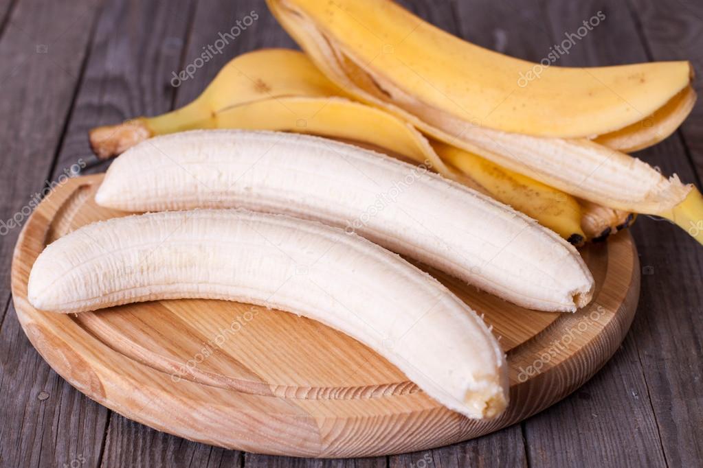 Peeled banana on a wooden board