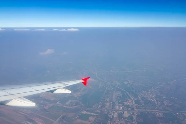 Gökyüzünde bir uçak kanadı Gökyüzü atmosferi bulutlu ve toz kalın. Asya kıtasına uç, Tayland.