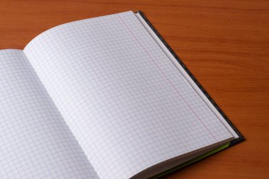 Ahşap bir arka planda açık bir defter. Boş sayfa.