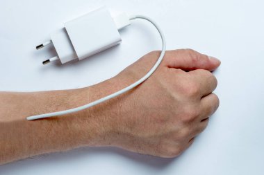 İnsan eline yerleştirilmiş bir şarj aleti. Şarj olmak, yorgunluk, enerji patlaması..