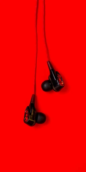 赤の背景に配線された真空ヘッドフォン — ストック写真
