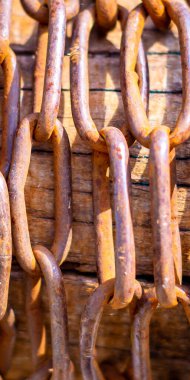 Metal zincirler - soyut arkaplan. Eski gemi çapa zincirlerinin sıraları birbirine yakın. Ahşap zeminde gemi çapa zinciri var..