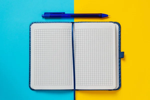 Cuaderno Blanco Azul Bolígrafo Azul Sobre Fondo Amarillo Azul Papelería — Foto de Stock