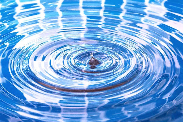 Salpicos de água. Uma gota de água a cair na piscina. Círculos na água. — Fotografia de Stock