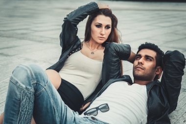 Genç trendy adam ve kadın modelleri modern Caddesi poz. Moda stil. yere yat