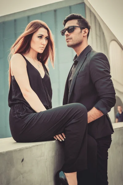 Young trendy man and woman models posing of the modern street. Fashion Style.