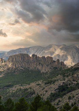 Huysuz bulutlar İspanya 'nın engebeli Puig Campana bölgesini gölgeleyerek dramatik kaya oluşumlarını ve manzaralı dağ manzarasında yemyeşil ormanları vurguluyor..