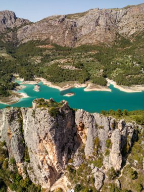 Çarpıcı bir turkuaz göl fotoğrafı. Etrafı dramatik kayalık uçurumlar ve Güney İspanya 'daki yemyeşil ormanlarla çevrili. Seyahat, macera ve doğa geçmişi için mükemmel..