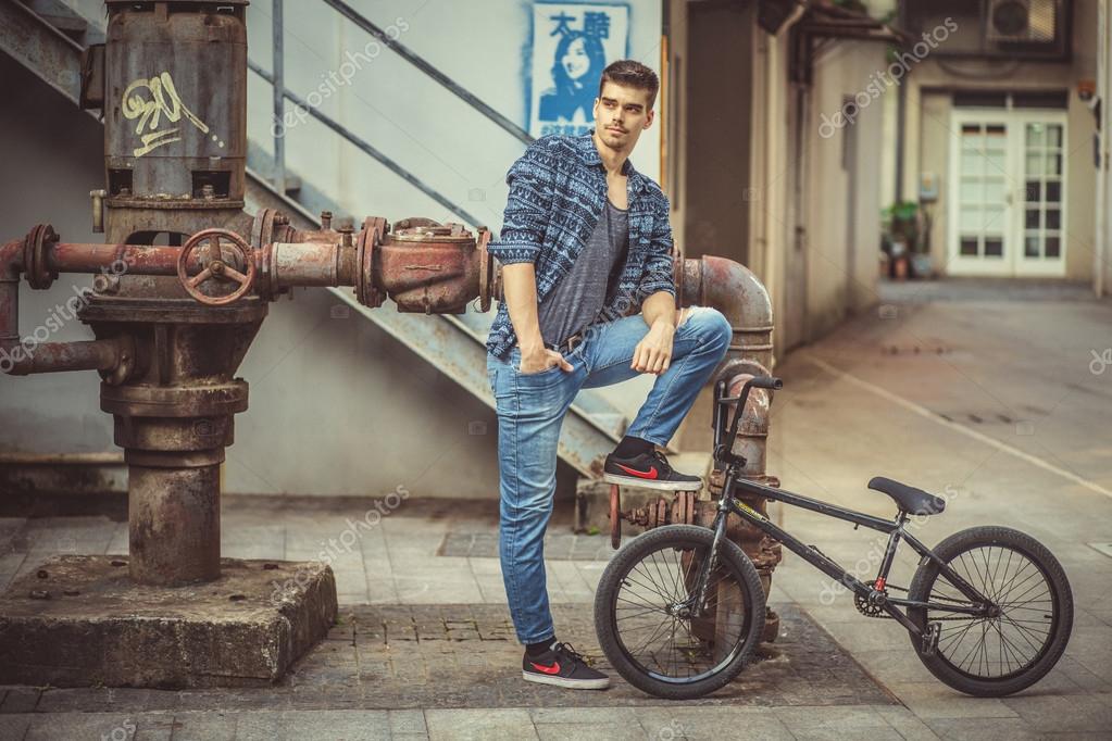 Young Stylish Man Model Posing Near The Loft Metal Tube And Bike Stock Photo Image By C Denyshutter 93285466 https depositphotos com 93285466 stock photo young stylish man model posing html