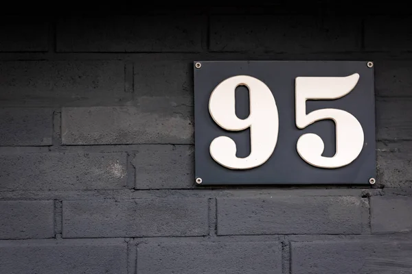 Koyu renkli tahta duvardaki beyaz 95 numaralı ev.