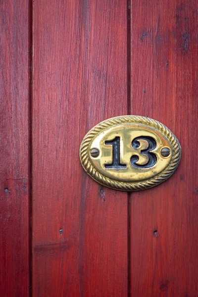 Thirteen in a gold oval metal plaque