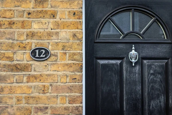 Siyah ahşap bir ön kapının yanında on iki tane.
