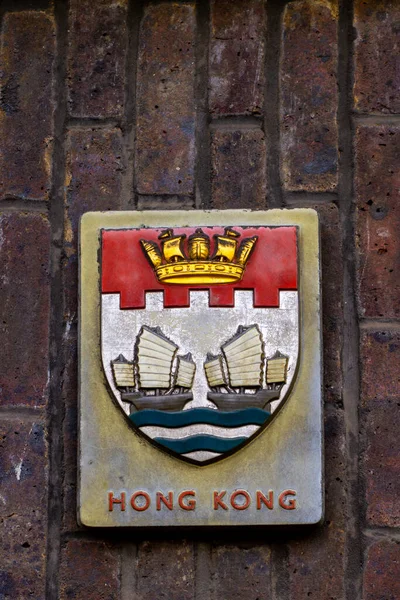 Hong Kong 'un küçük arması, iki Çin hurdası ve altın bir deniz tacı.