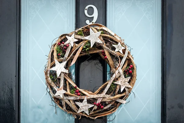 9 numaralı kapıda yıldızlar olan bir Noel çelengi.