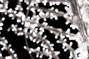 Arka plan için odaklanmış beyaz bokeh ışıkları - tatiller, dekorasyon ve parti konsepti. Gümüş ve beyaz bokeh ışıkları. Soyut duvar kağıdı. Siyah arkaplanda Bokeh ışıkları, koyu, bulanık dokuda.