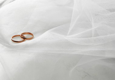 Bir çift altın yüzük ve inci kolye ile düz bir zemin üzerinde gelinin beyaz bir peçesi ile süslenmiş nişan veya düğün için fotokopi alanı. Aşk konsepti, üst görünüm, dizilin. Pankart