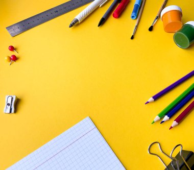 Renkli üstten okul malzemeleri. Okul kırtasiyesi ile yaratıcı çerçeve düzeni. Düz yatıyordu. Renkli kırtasiye. İzole edilmiş arka plan. Uzayı kopyala Okula dönelim. Pankart