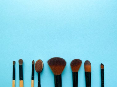 Fotokopi aletiyle düz bir zemini fırçalar. Güzellik kozmetik makyaj ürünü düzeni. Şık tasarım. Yaratıcı moda konsepti. Mavi arka planda kozmetik makyaj fırçası koleksiyonu, üst görünüm.