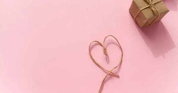 Pakowanie Prezentów Papier Kraft Sercem Wykonanym Nici Różowym Tle Minimalizm — Zdjęcie stockowe