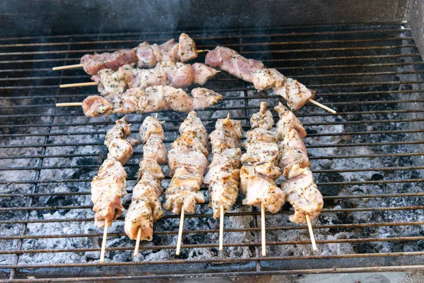 Torrefazione bastoncini di carne souvlaki sulla griglia a carbone caldo fuoco. Carne di maiale, pollo street food greco carne alla griglia. — Foto Stock