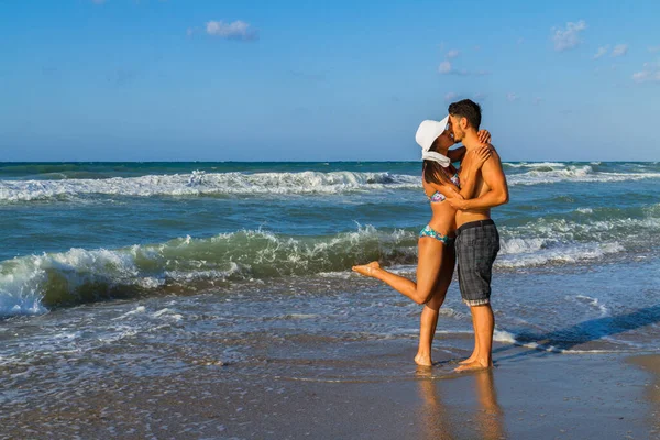 Atractiva pareja joven en bikini y pantalones cortos en la playa. —  Fotos de Stock