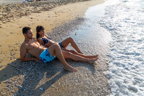 Caucasian young couple enjoying summer holidays relaxing on sand beach. — Stock Photo, Image