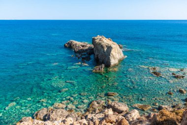 Kristal berrak turkuaz mavi okyanus suları. Güneydoğu kıyı şeridi çakıl taşları ve kayalarla, Grete Yunanistan. Seyahat tatili kavramı.