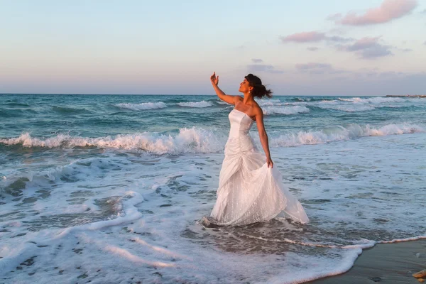 Jeune mariée jouit d'une promenade solitaire sur la plage au crépuscule Images De Stock Libres De Droits