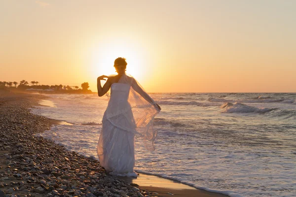 Gece karanlığında puslu bir kumsalda yürüyen genç gelin sahiptir. — Stok fotoğraf