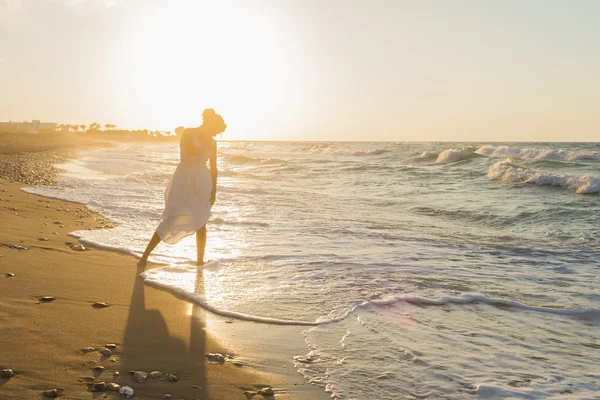 Jeune femme aime marcher sur une plage brumeuse au crépuscule . Images De Stock Libres De Droits