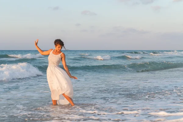 Young woman enjoys a lonesome walk on the beach at dusk. — Stock Photo, Image