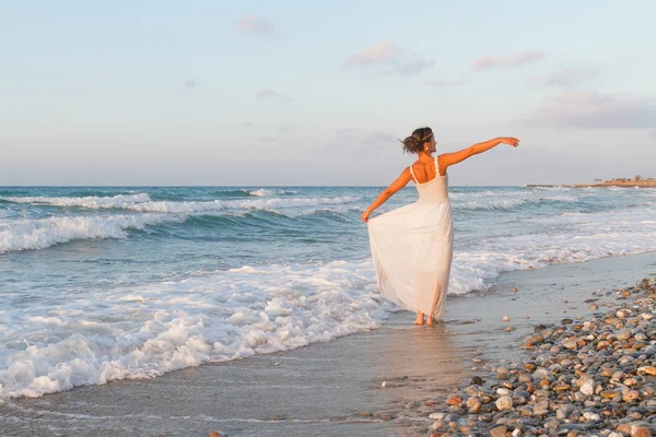 Jeune femme jouit d'une promenade solitaire sur la plage au crépuscule . Photos De Stock Libres De Droits