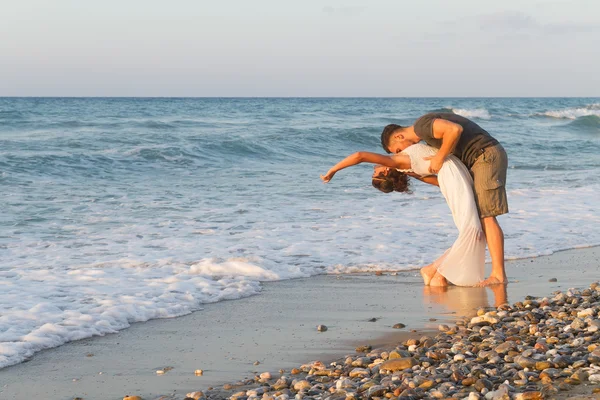 对年轻的夫妇喜欢在黄昏时在朦胧的海滩上散步. — 图库照片