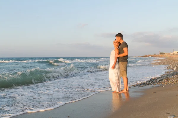 Jeune couple aime marcher sur une plage brumeuse au crépuscule . Photos De Stock Libres De Droits