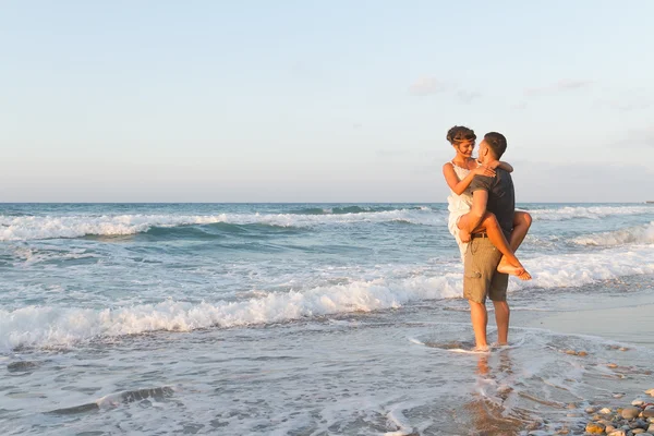Νεαρό ζευγάρι απολαμβάνει το περπάτημα σε ένα μουντό παραλία σούρουπο. — Φωτογραφία Αρχείου