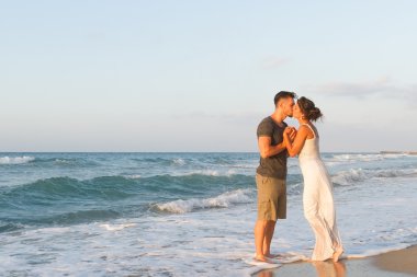 Genç çift gece karanlığında puslu bir sahilde yürüyüş sahiptir.