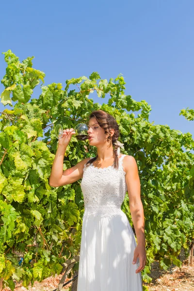 Giovane contadina assaggia un bicchiere di vino rosso . — Foto Stock