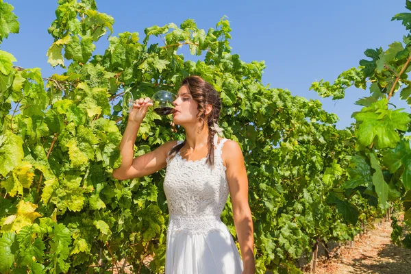 Giovane contadina assaggia un bicchiere di vino rosso . — Foto Stock